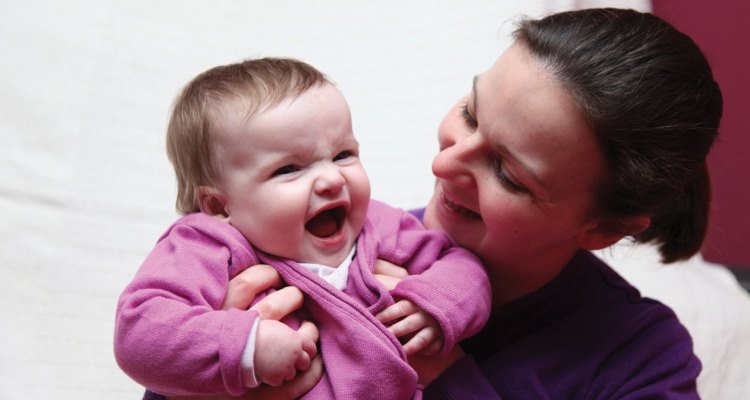 A laughing baby with her mother