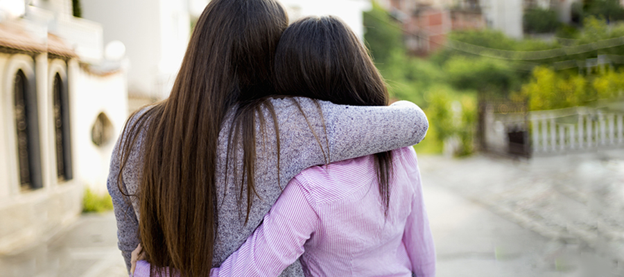 An adult and teenager hugging