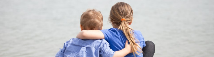 Two children hugging, facing away from the camera