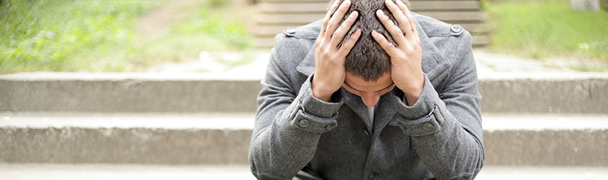 A distressed young person with their head in their hands