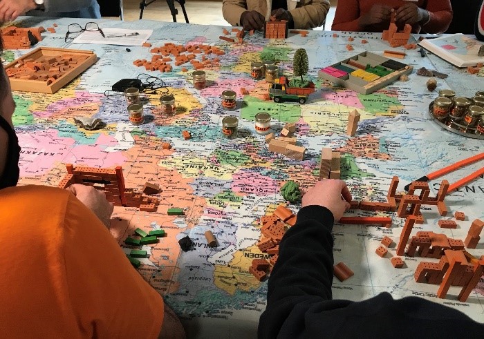 Young refugees looking at a map and describing their journeys