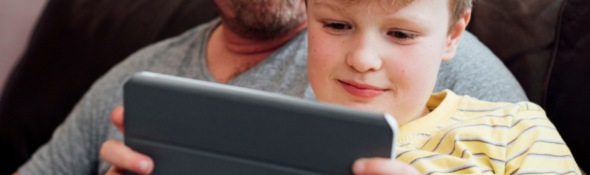 father and son looking at a tablet