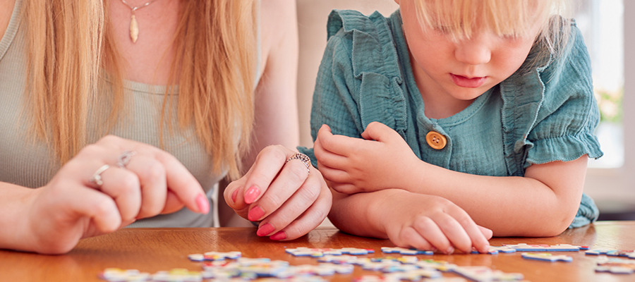 A parent and child doing a jigsaw