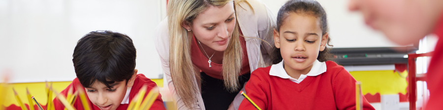 A teacher helping a young pupil