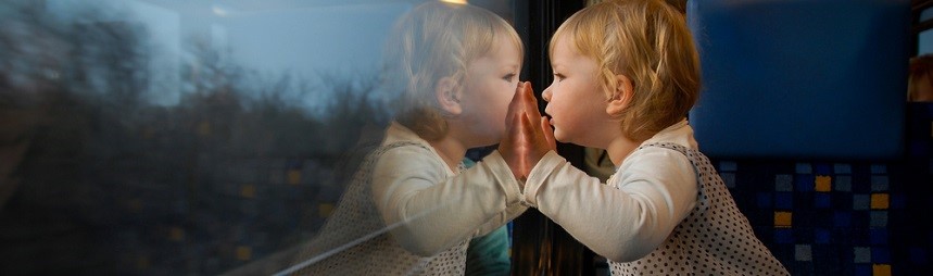 A toddler looking through a train window