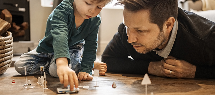 Parent and child playing with cars