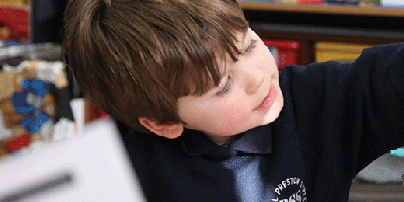 A boy pointing at his school work