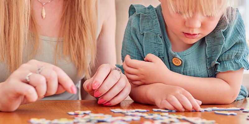 A parent and child doing a jigsaw