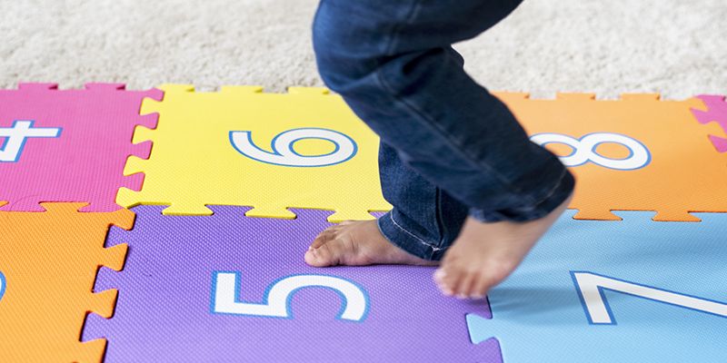 A close up of a child's feet aa they play hopscotch