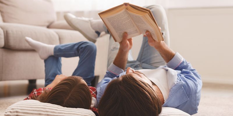 An adult and child reading a book