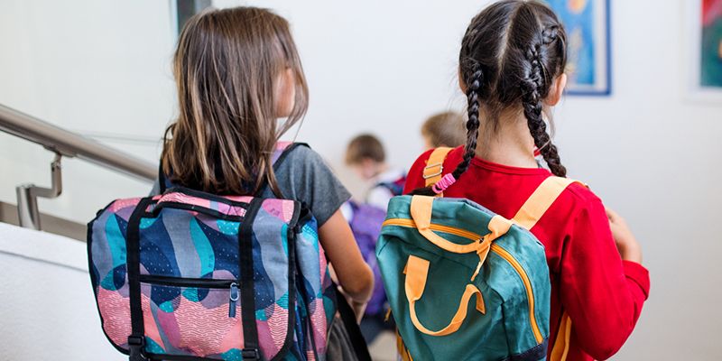 Two children wearing back packs