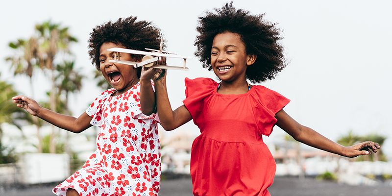 Children running and playing with a toy plane