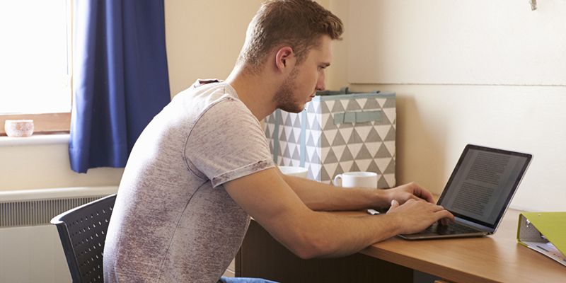 A young man on a laptop at home