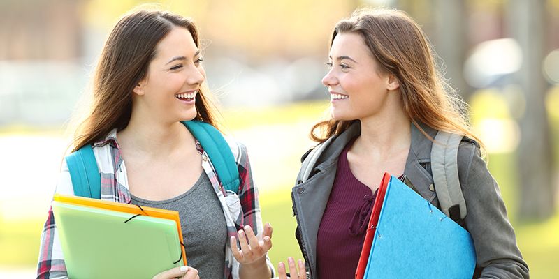 two teenage students chatting