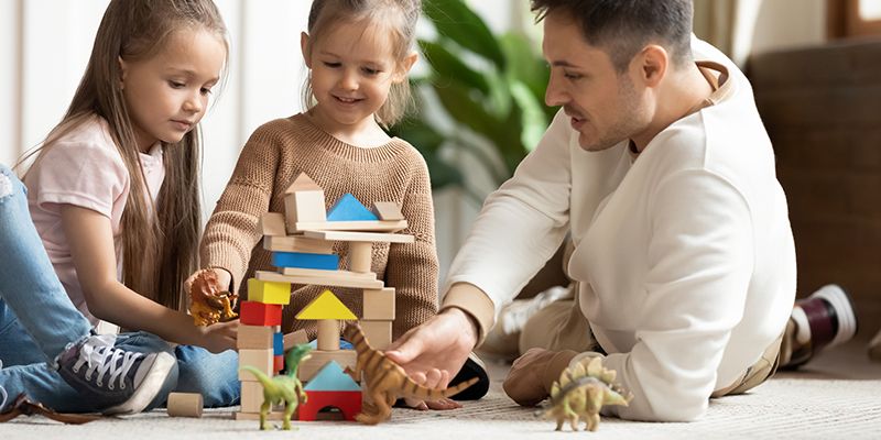 A child and parent playing with wooden blocks