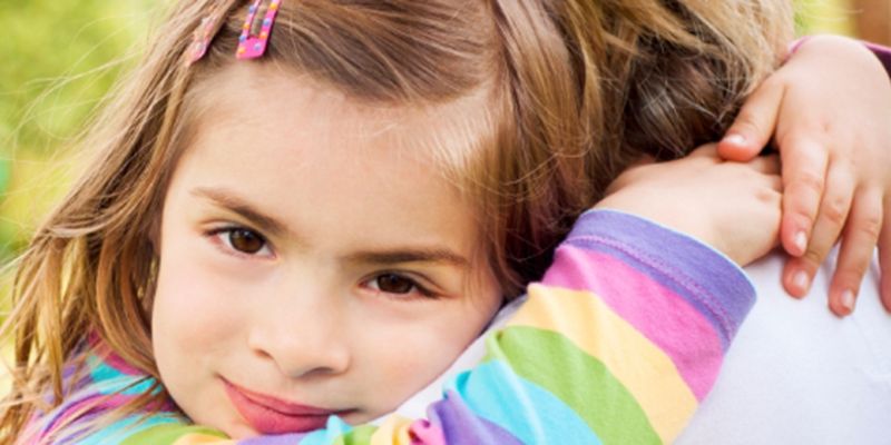 A young girl hugging a parent