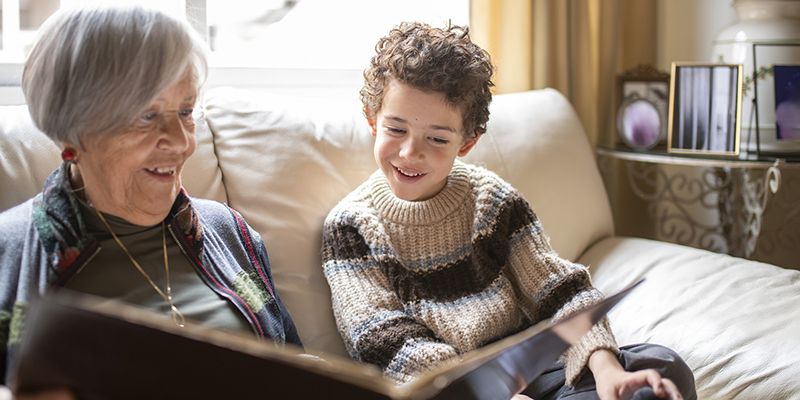 Grandmother and grandchild looking at a photo album