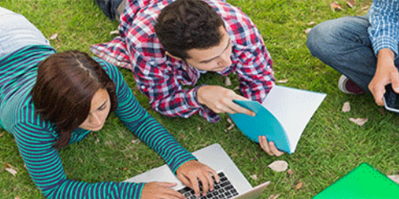 Students lying on grass studying