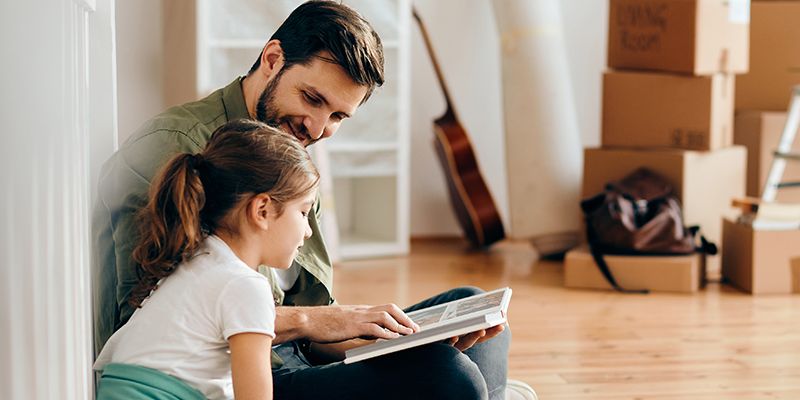 A parent reading to their young daughter