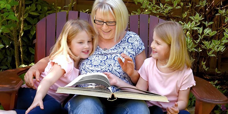 An adult reading to two children