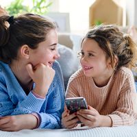 Two girls looking at a mobile phone