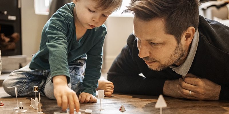 Parent and child playing with toy cars